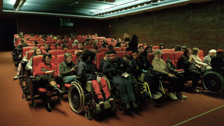 Foto de sala de cinema com pessoas em cadeiras de rodas mostrando que no Brasil, a acessibilidade nos cinemas é adiada.