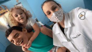 Criança com paralisia cerebral e sua irmã, com a fisioterapeuta, para o texto Sobre o Capacitismo.