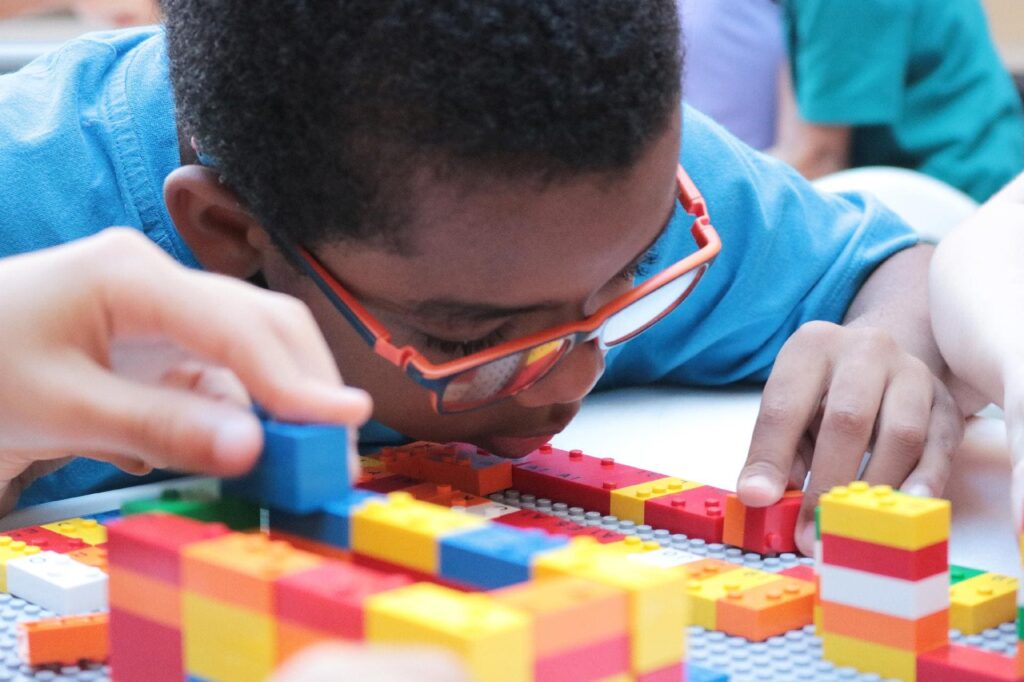 Foto de criança negra com deficiência visual ilustrando LEGO Braille Bricks: Novidade às vésperas do Dia Mundial do Braile