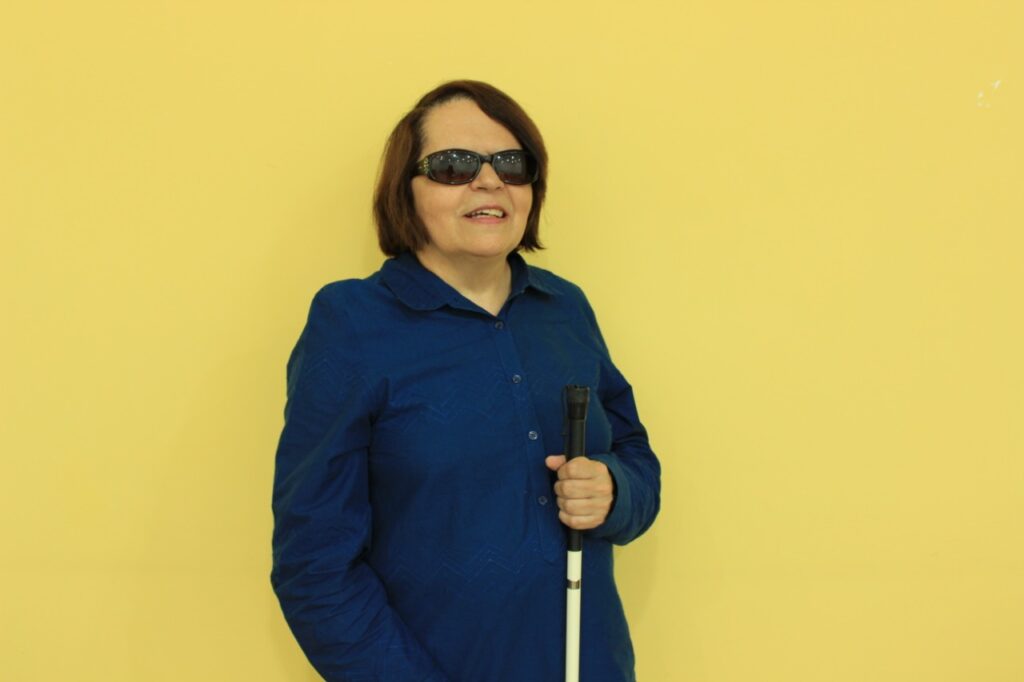 Foto de Regina Oliveira, pessoa com deficiência visual, ilustrando artigo sobre Dia Mundial do Braille.