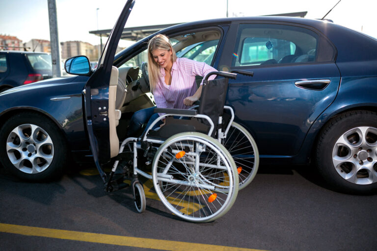 Mulher branca dentro de carro se transferindo para cadeira de rodas, ilustrando nota Mudanças na isenção do IPI de veículos para PcDs em debate nesta segunda (19).