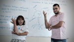 Fotografia com criança e adulto, em sala de aula, com descrição na legenda do texto sobre “Senado debate educação bilíngue para surdos".