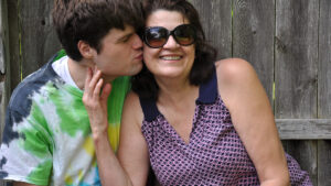 Filho beijando o rosto da mãe. Descrição na legenda da reportagem sobre "Os desafios do autista adulto".