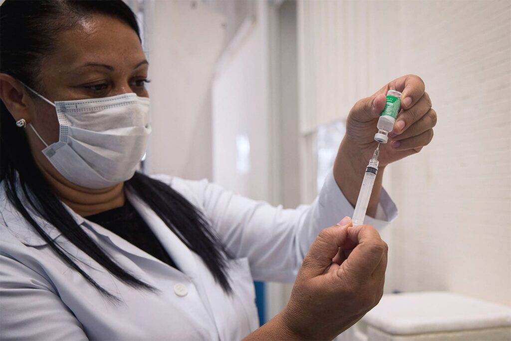 Na imagem, profissional da saúde preparando aplicação de imunizante contra COVID-19.