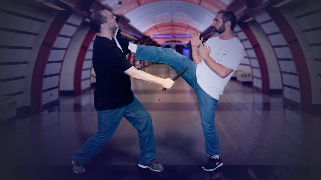 Fotografia com duas pessoas fazendo demonstração da técnica Krav Magá