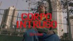 Imagem do clipe com o rapper cadeirante e o texto: "Corpo Intruso. Billy Saga".