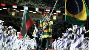 Fotografia do medalhista Daniel Dias, na cerimônia de encerramento da Paralimpíada no Japão, em Tóquio, dia 5 de setembro. Daniel carrega a bandeira do Brasil.