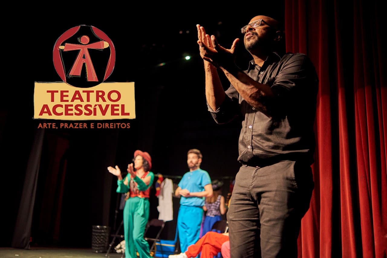 Foto de ator negro, gesticulando com as mãos, no palco, e sobreposição do logotipo da Oficina de Teatro Acessível.