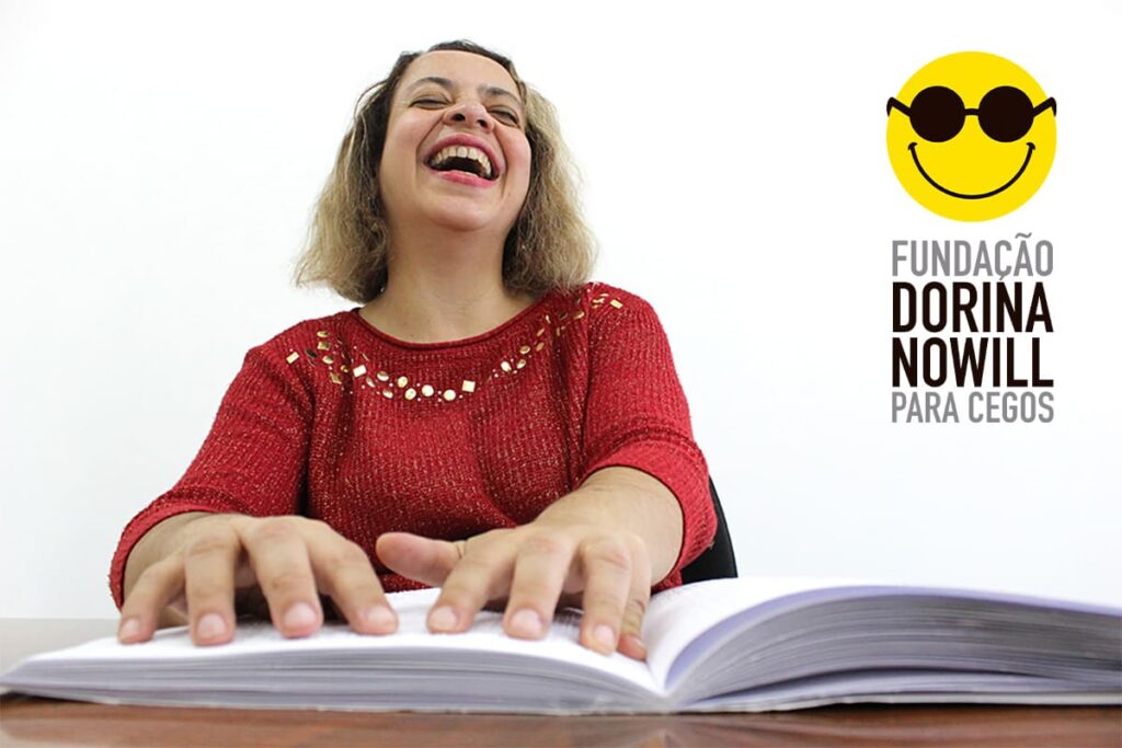 Mulher com deficiência visual fazendo leitura em Braille, pelo Dia Nacional do Livro 2021. Descrição detalhada na legenda, abaixo.
