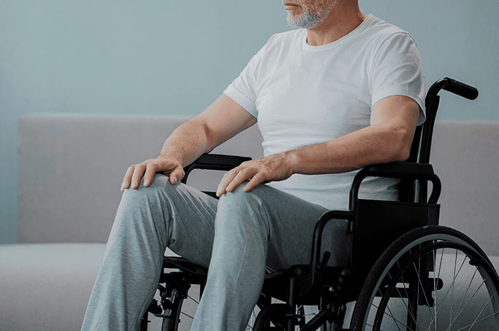 Homem idoso sentado em cadeira de rodas.