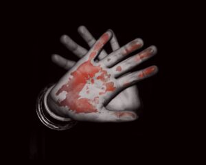 Foto de duas mãos, umas delas com a palma ensanguentada, ilustrando aumento da violência contra PcDs em 2021..
