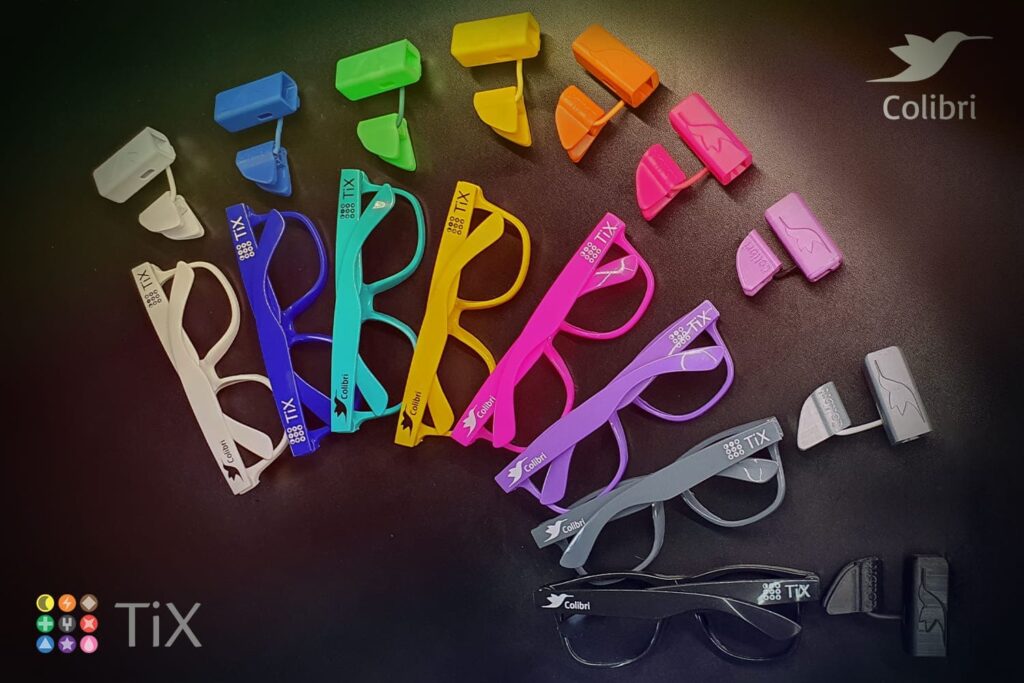 Foto do mouse de cabeça Colibri, da startup TiX, e das armações de óculos que acompanha o dispositivo em diversas opções de cores.