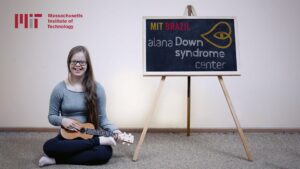 Imagem de uma jovem com síndrome de Down com o Ukulele, descrita na legenda abaixo, sobre "MIT oferece bolsa de pós-doutorado sobre síndrome de Down".