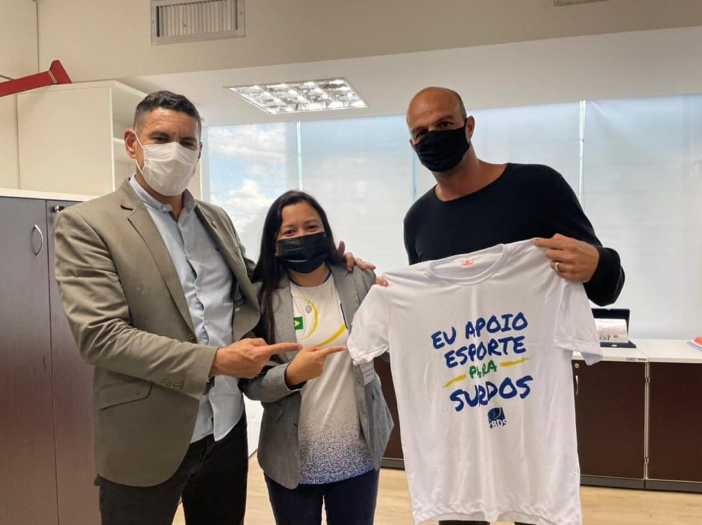 Foto com Diana, Agtônio e Bruno, exibindo camiseta branca com a informação: “Eu apoio Esporte para Surdos”.
