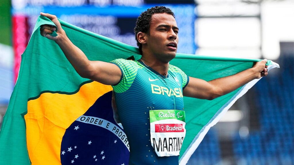 Foto colorida do atleta paralímpico Daniel Martins, medalha de ouro na Rio 2016. Está correndo na pista de atletismo, atletismo, uma das modalidades mais praticadas na deficiência intelectual.