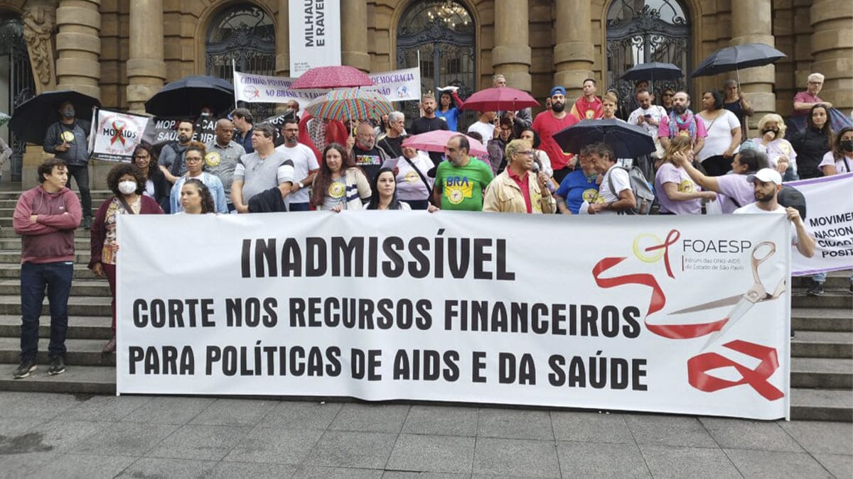 Manifestantes na escadaria do Theatro Municipal de São Paulo com cartazes em Defesa da Política de Aids no Brasil. Crédito: Agência Aids