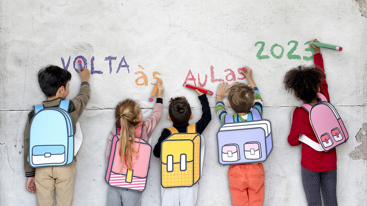 Crianças com mochilas nas costas, estão lado a lado, escrevendo na parede a frase: “Volta às aulas 2023”, beneficiadas pela norma aliada da inclusão escolar.