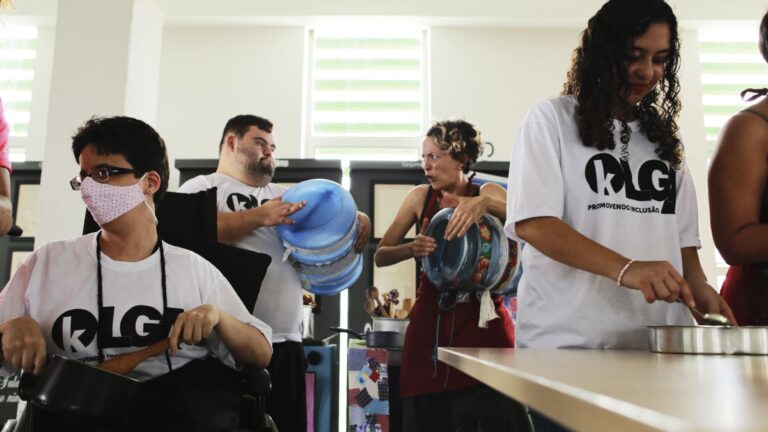 Foto de pessoas com deficiência e monitora do Instituto Olga Kos batucando em utensílios de cozinha. A ação é do projeto Batuque na Cozinha, que será encerrado com o Espetáculo Pulsar.