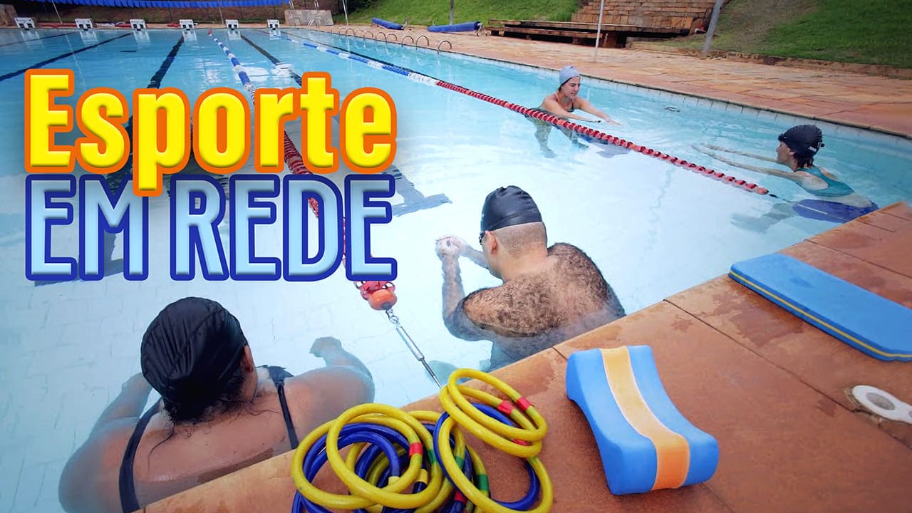 Foto com texto: Esporte em Rede, mostra pessoas com deficiência visual dentro da piscina. Estão acompanhadas por instrutores, usando toca de cabelo e óculos de natação.