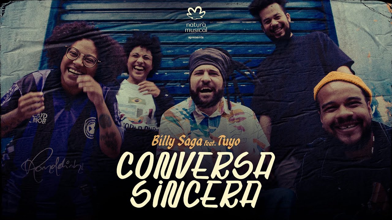 Imagem com texto: Natura Musical apresenta rapper Billy Saga e banda Tuyo - Conversa Sincera. Foto do rapper com quatro integrantes da banda em frente uma porta azul de ferro.