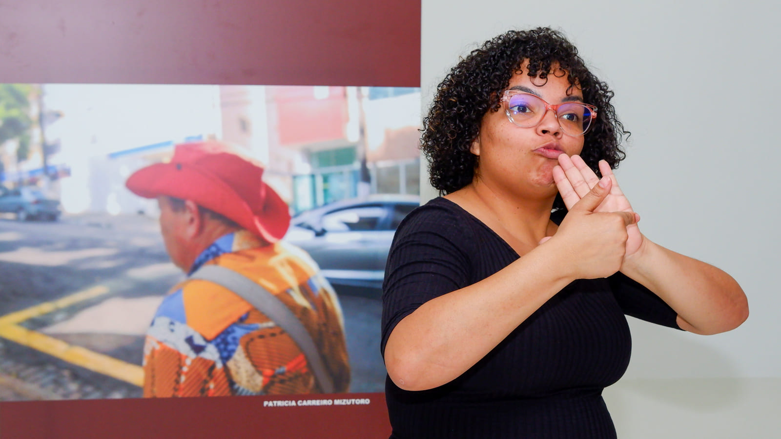Intérprete de Libras na cerimônia de lançamento da exposição fotográfica “Apropriação da Paisagem”, no Museu da Inclusão.