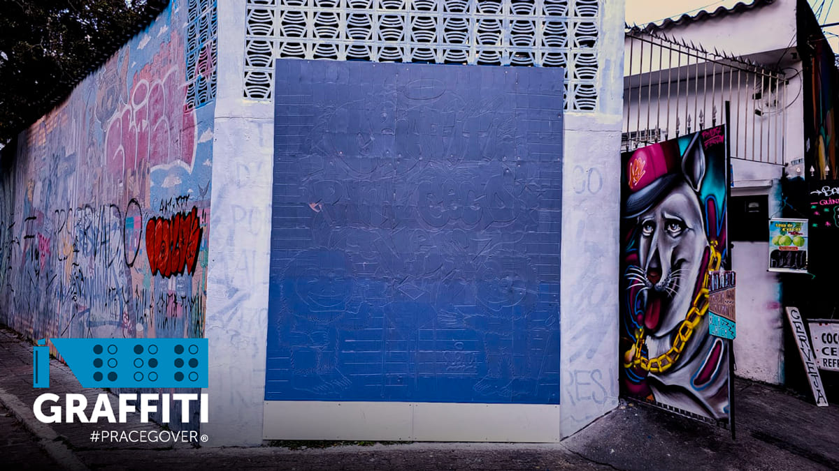 Foto em área externa. No centro, a primeira parede de grafite em braille do mundo, no Beco do Batman, em São Paulo. Sobreposição da logo do projeto Graffiti #PraCegoVer, promovendo a arte urbana acessível para pessoas com deficiência visual, no canto esquerdo inferior.