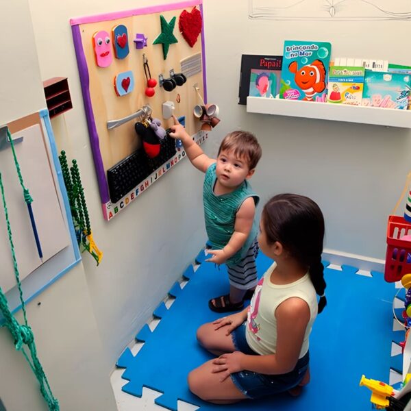 Foto com duas crianças em um quarto transformado em espaço sensorial para o desenvolvimento da criança autista.