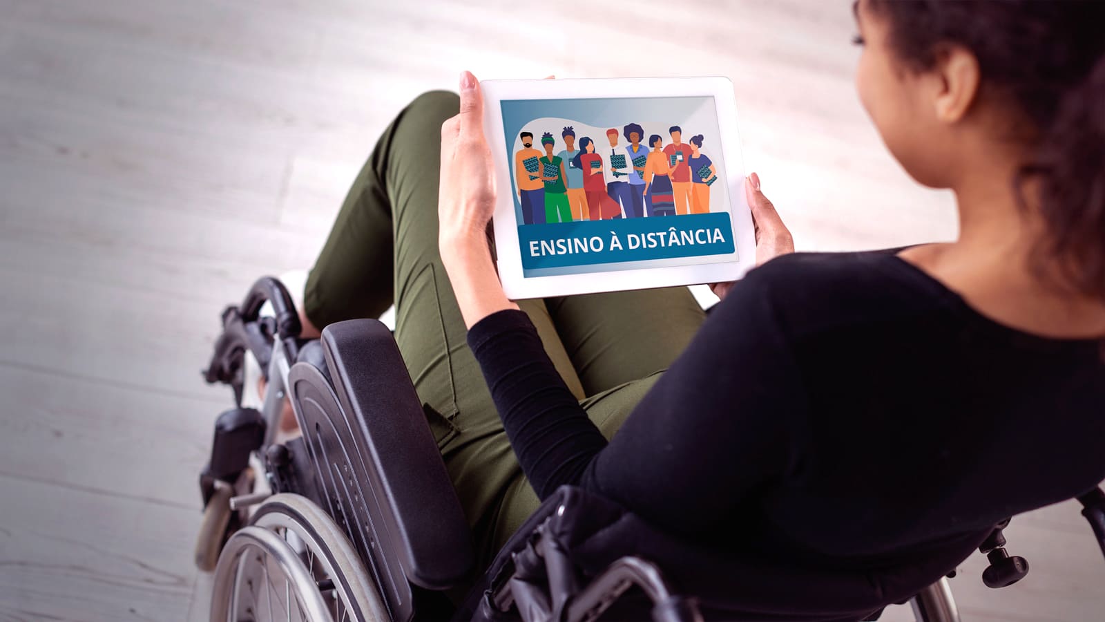Pessoa em cadeira de rodas segura um tablet, com imagem de estudantes com deficiência de diferentes etnias e gêneros com o texto: Ensino à distância - EAD - Ensino Superior em 2022.