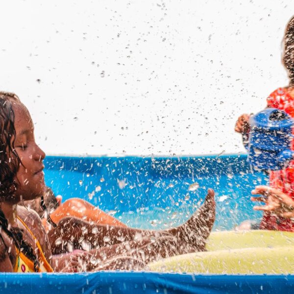 Crianças se divertindo em uma piscina inflável, entre as atividades acessíveis de férias no Galpão Bela Maré, do Bela Verão 2024.