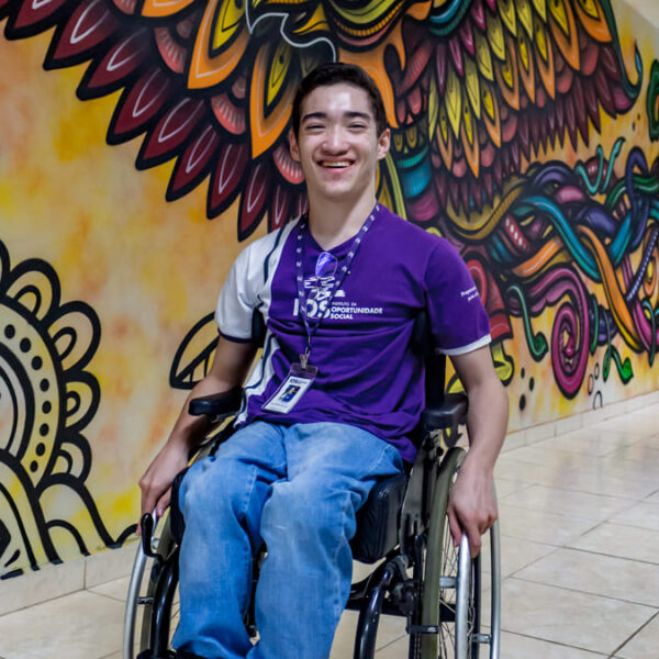 Pessoa com deficiência em frente a um mural colorido no IOS. Ilustra o programa TECPro, curso online gratuito para PcDs com bolsa de R$ 200.