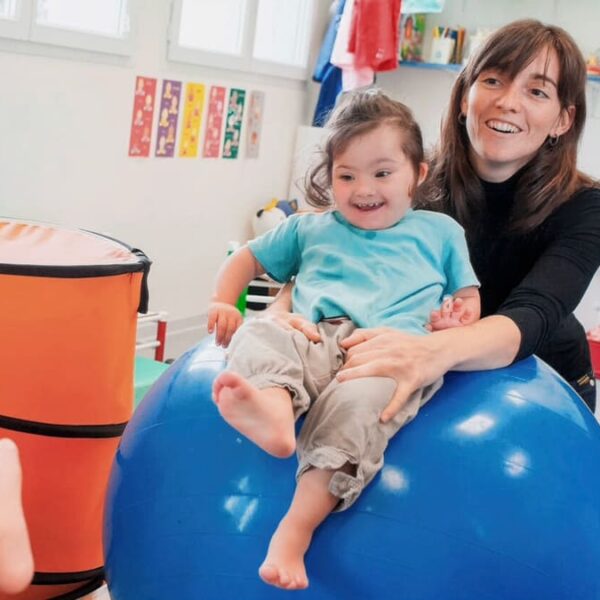 Fisioterapeuta e criança com Trissomia 21 em uma sessão de terapia Baby Bobath.