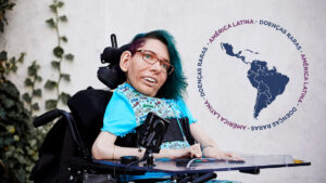 Pessoa em cadeira de rodas com mapa da América Latina ao fundo e texto ‘Doenças Raras na América Latina
