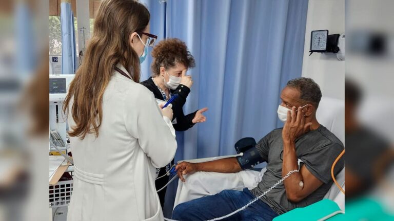 Intérprete de Libras Valéria Toniolo atendendo paciente surdo no Instituto do Coração, do complexo HCFMUSP.