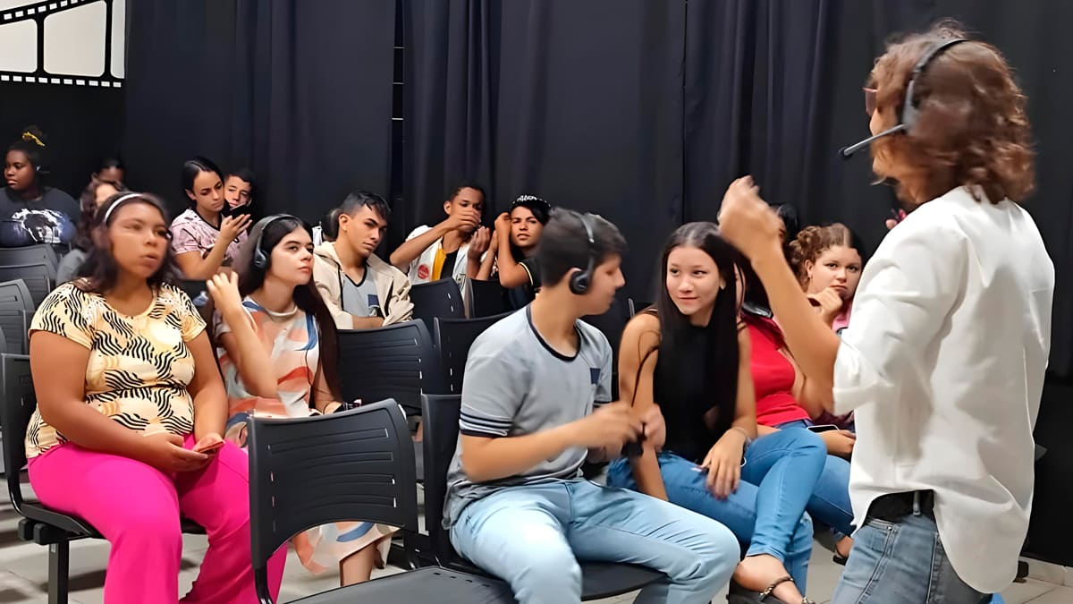 Grupo de pessoas participando do curso online de audiodescrição para cinema, com algumas usando fones de ouvido, enquanto interagem com a instrutora Bell Machado.