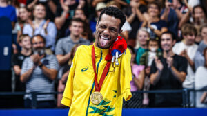 Brasil tem estreia promissora com ouro de Gabrielzinho, o nadador paralímpico mostra a língua de forma brincalhona, em pé na frente da plateia animada, com sua medalha em volta do pescoço.