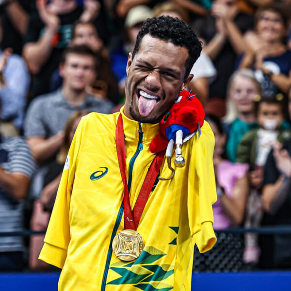 Brasil tem estreia promissora com ouro de Gabrielzinho, o nadador paralímpico mostra a língua de forma brincalhona, em pé na frente da plateia animada, com sua medalha em volta do pescoço.