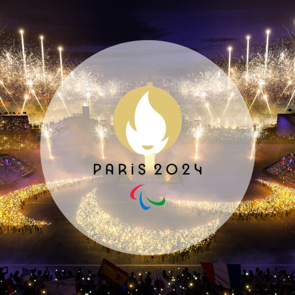 Representação da cerimônia de abertura dos Jogos Paralímpicos Paris 2024, com fogos de artifício e o logo oficial iluminando a cena.