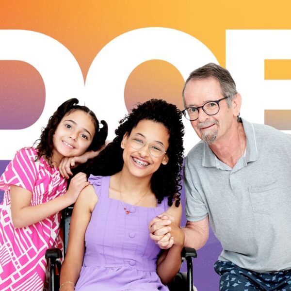 Allice, Fernanda e Lécio, pacientes-símbolo da campanha AACD Teleton 2024, sorrindo juntos em frente ao fundo colorido com a palavra "DOE" em destaque.