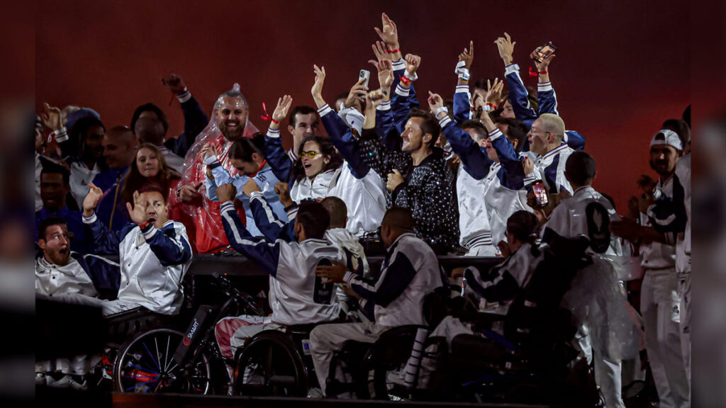 Atletas comemoram na cerimônia de encerramento dos Jogos Paralímpicos de Paris 2024, muitos em cadeiras de rodas, na celebração que marca a festa da inclusão Paralímpica no Stade de France.