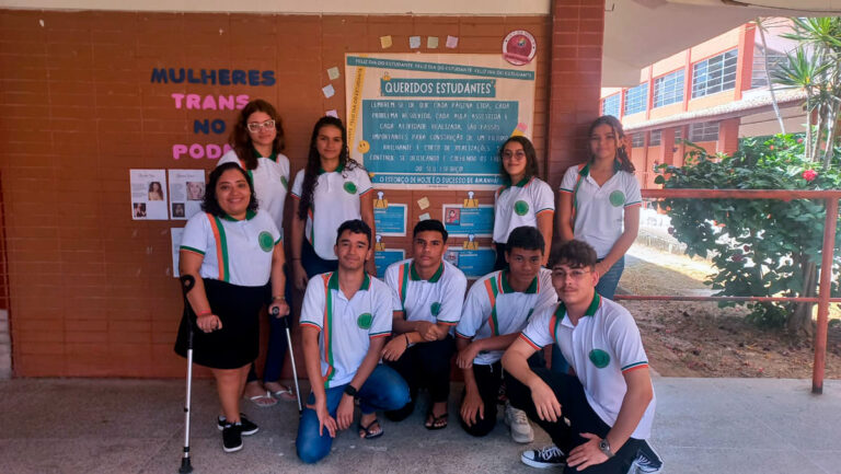 Grupo de estudantes em frente a um mural escolar, autores de um projeto de empoderamento de mulheres com deficiência, representando Paramoti no Ceará Científico 2024.