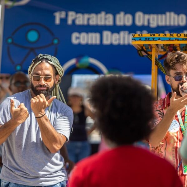 Intérprete de Libras traduz discurso durante a 1ª Parada do Orgulho PCD de Salvador, promovendo acessibilidade para a comunidade surda.