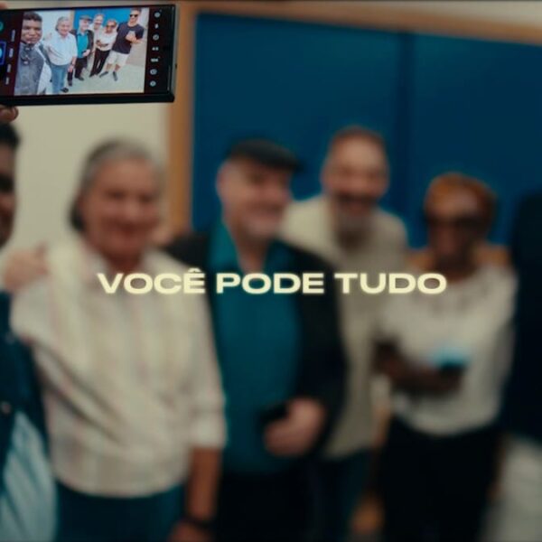 O fotógrafo cego João Maia segura o celular para tirar uma selfie com um grupo diverso, acompanhado da frase "Você pode tudo" ao centro da imagem. (Foto: Reprodução)