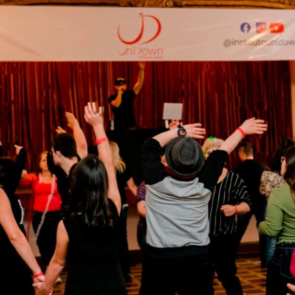 Pessoas dançando em um salão decorado durante o evento Baladown Junina, promovido pelo Instituto UniDown. (Foto: Divulgação)