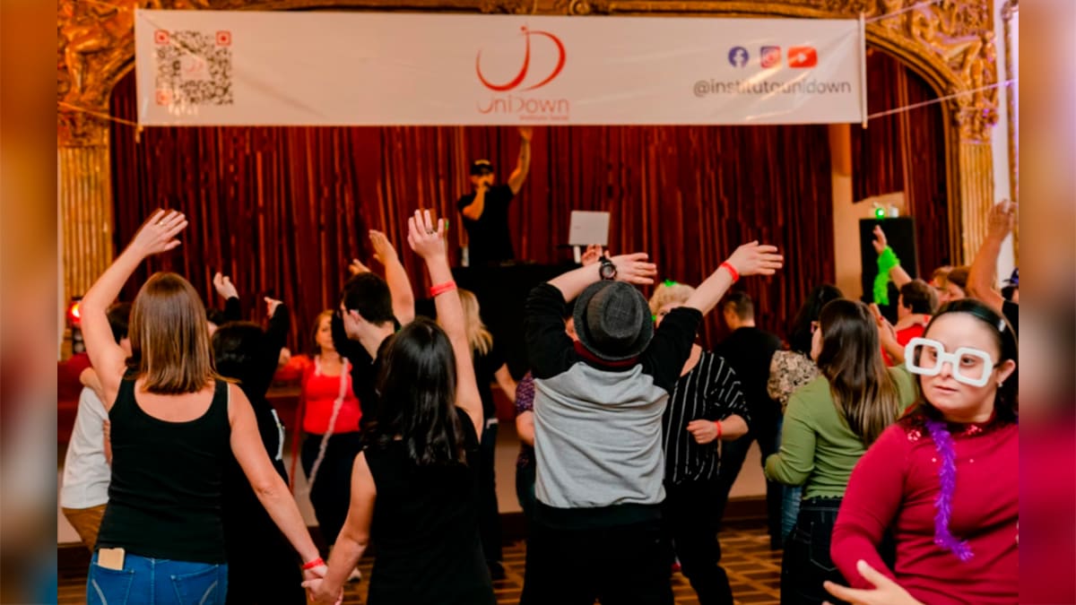 Pessoas dançando em um salão decorado durante o evento Baladown Junina, promovido pelo Instituto UniDown. (Foto: Divulgação)