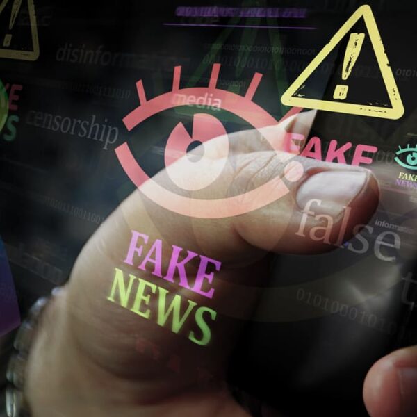 Mão segurando celular com alertas de fake news, desinformação e censura sobrepostos na tela, representando propagação de notícias falsas e desinformação sobre autismo no Brasil. (Créditos: Depositphotos)