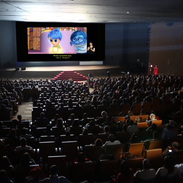 Público assiste ao filme "Divertida Mente" em sessão acessível com intérprete de Libras no Festival de Cinema Acessível Kids 2025. (Créditos: Divulgação)