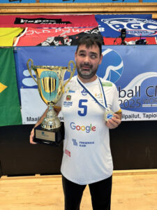 O paratleta Alan Nogueira segurando troféu e medalha, vestindo uniforme de time com o número 5 e logotipos de patrocinadores, após vitória no Mundial de Goalball 2025. (Créditos: Divulgação)