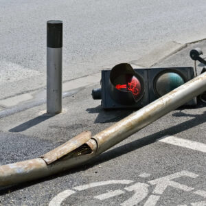 Sinaleiro caído sobre ciclovia e calçada, com o sinal vermelho de pedestres aceso, indicando perigo e insegurança na travessia com semáforos em SP. (Foto: Depositphotos)
