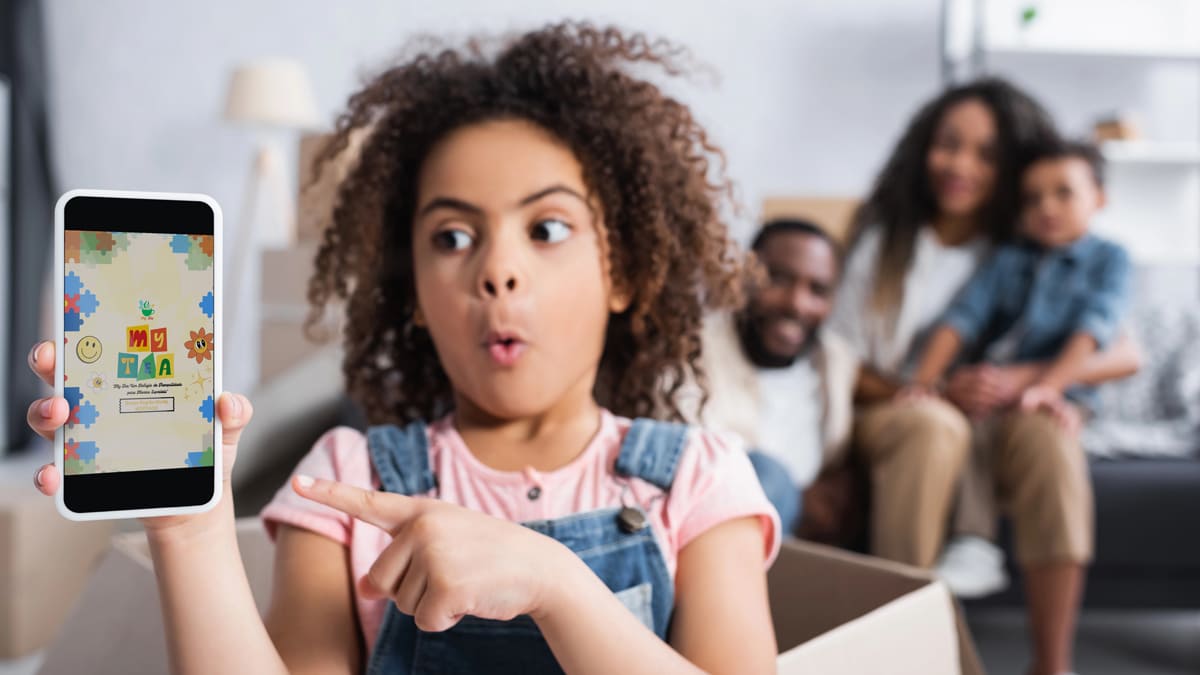 Menina encantada mostra celular com a tela do aplicativo My Tea, enquanto família assiste ao fundo sorrindo. (Foto: Depositphotos/Divulgação)