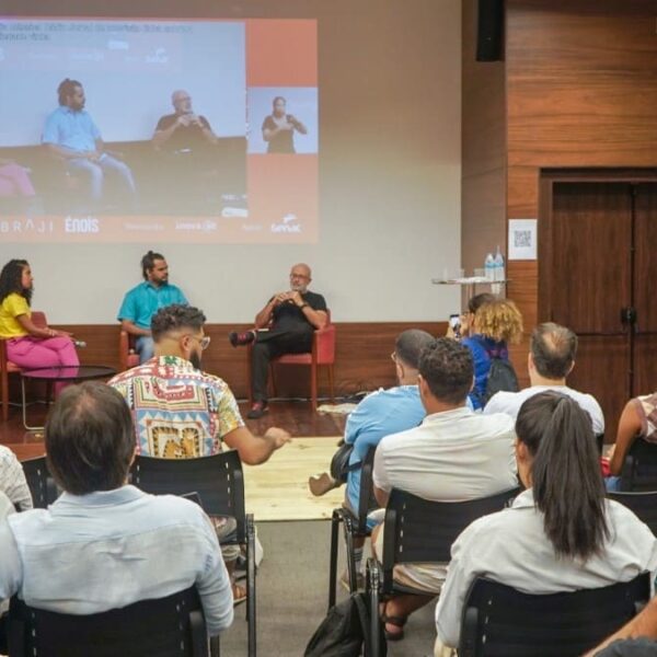 Roda de conversa no Congresso Inova.aê, com três palestrantes no palco e intérprete de Libras ao lado. O público acompanha a atividade em auditório, com projeção ao fundo ampliando a visualização do evento. (Foto: Divulgação)